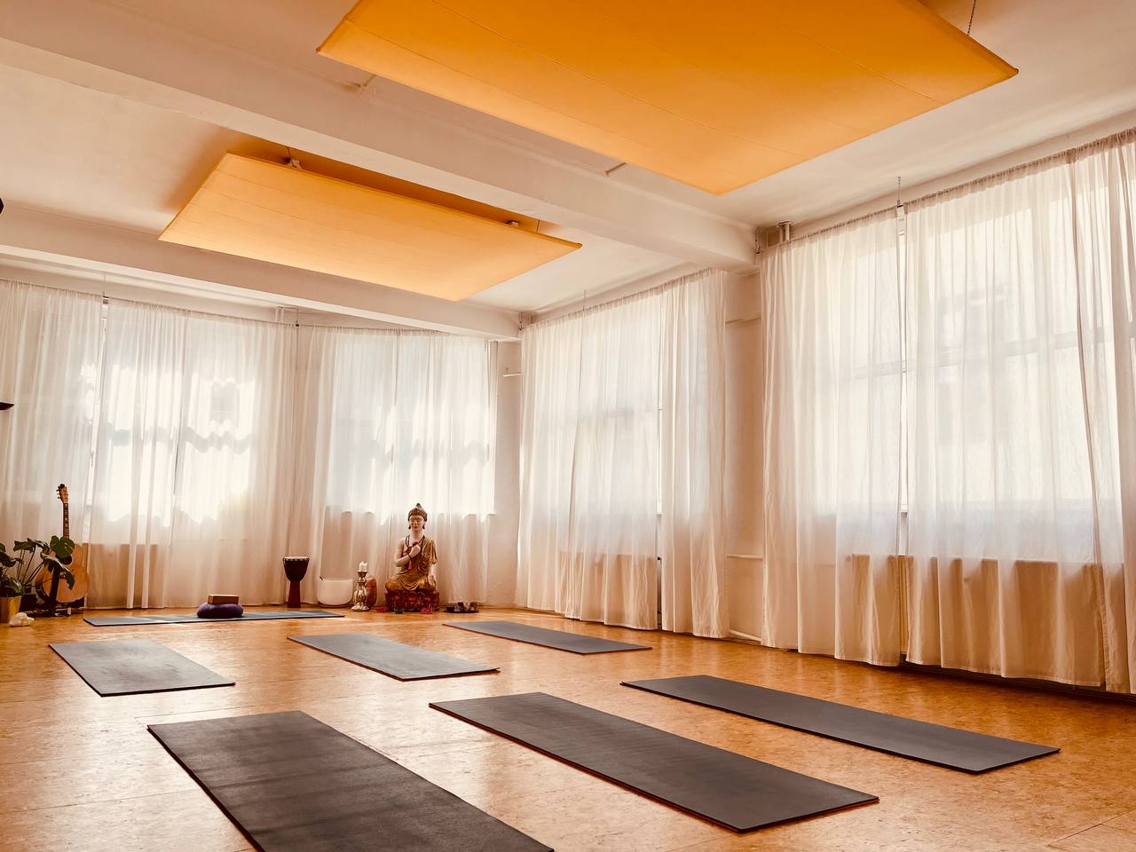 Yogastudio Steffen mit Yogamatten und Bodhisattva-Figur im Hintergrund