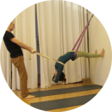 Yoga Übungen im Seil – intensive Rückbeuge im Gurt hängend mit zusätzlichem Gurtzug durch Partner