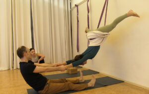 Flying Yogi: Fliegende Yoga-Umkehrhaltung im Seil an der Wand