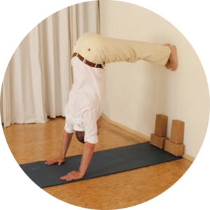 Steffen im Halben Handstand an der Wand im Hatha Yoga